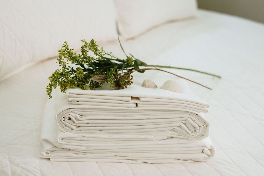 A pile of white cloth with a green bag on it