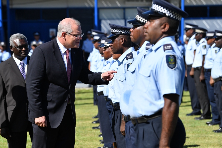 Australian Prime Minister Scott Morrison vets a group of Solomon Islands police after arriving in the country in 2019