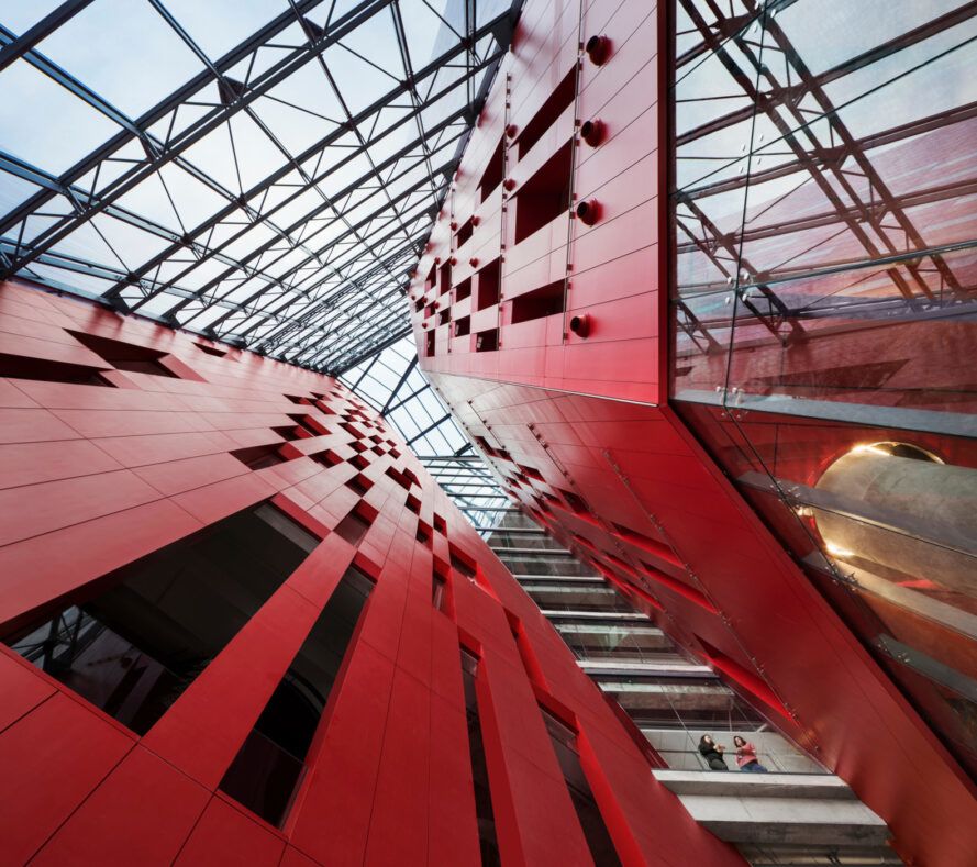 Shot from the ground up to the red design leading to the glass ceiling