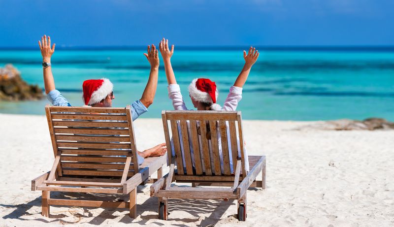 couple wearing santa hats on the beach