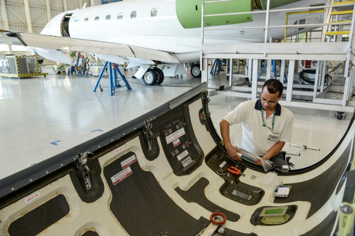 An employee works on an aircraft assembly line